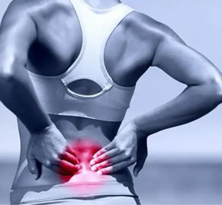 Mujer sujetando la zona lumbar por dolor en el cóccix o coxidinia