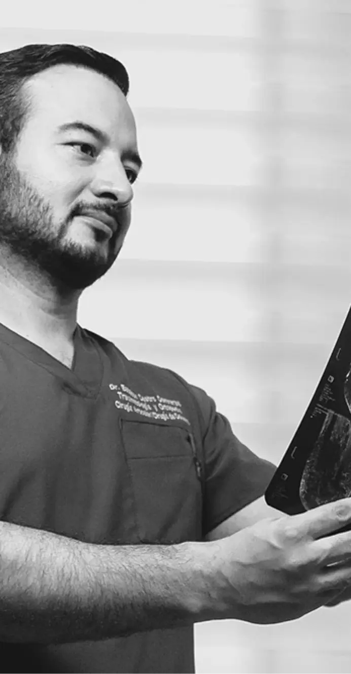 Dr. Esteban Castro evaluando radiografía de columna vertebral en su consultorio de Guadalajara